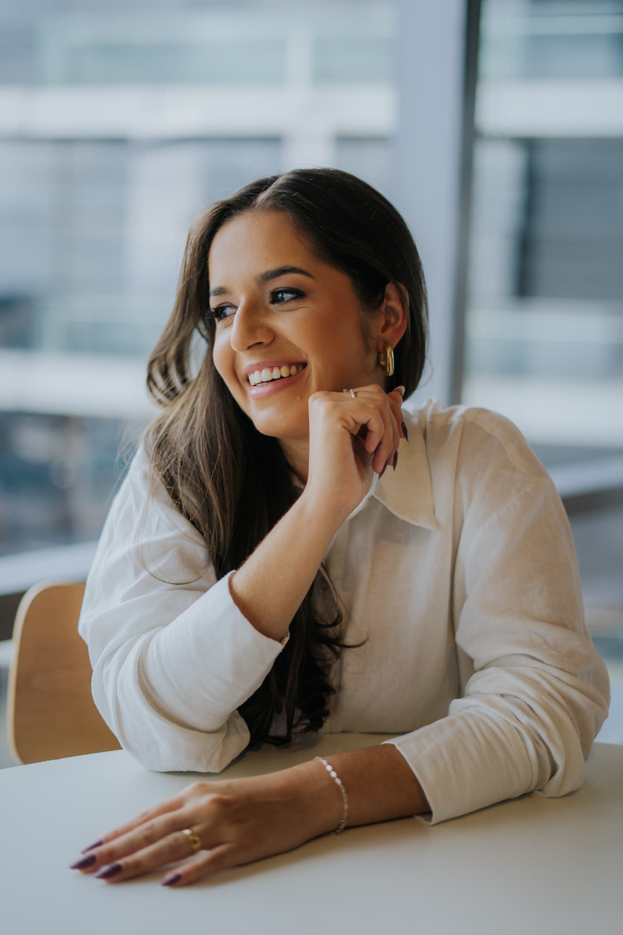 Bianca Simão, fundadora do Instituto Exaltere, sorrindo sentada à mesa