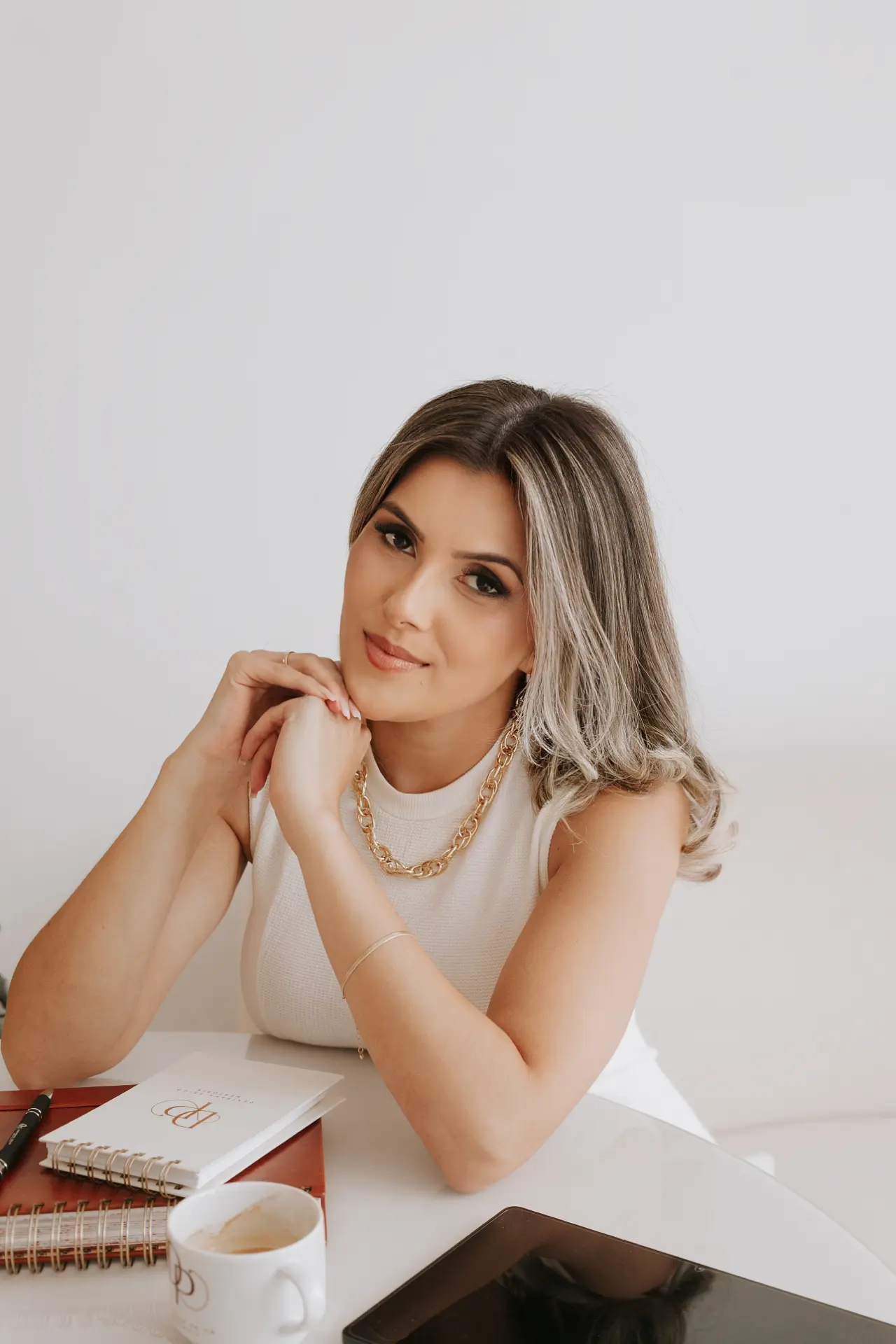 Jaqueline, psicopedagoga, sentada à mesa de trabalho